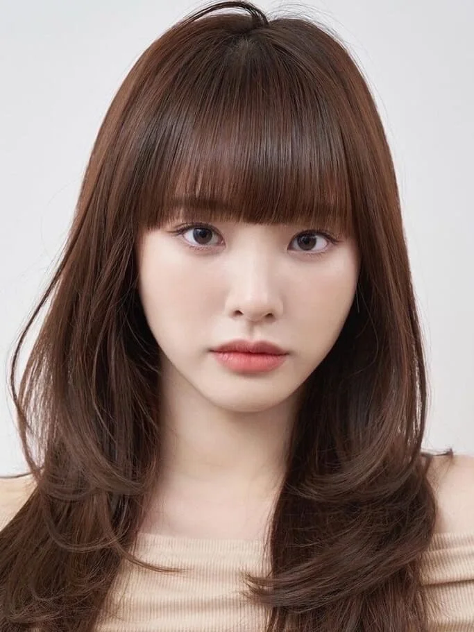 Medium length haircut with full bangs and smooth rounded layers for thin fine hair