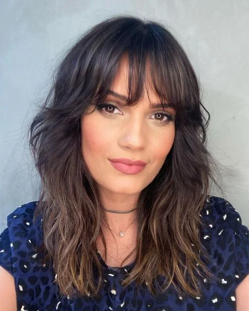 Tousled medium shag haircut with bangs and lived-in texture for thin fine hair