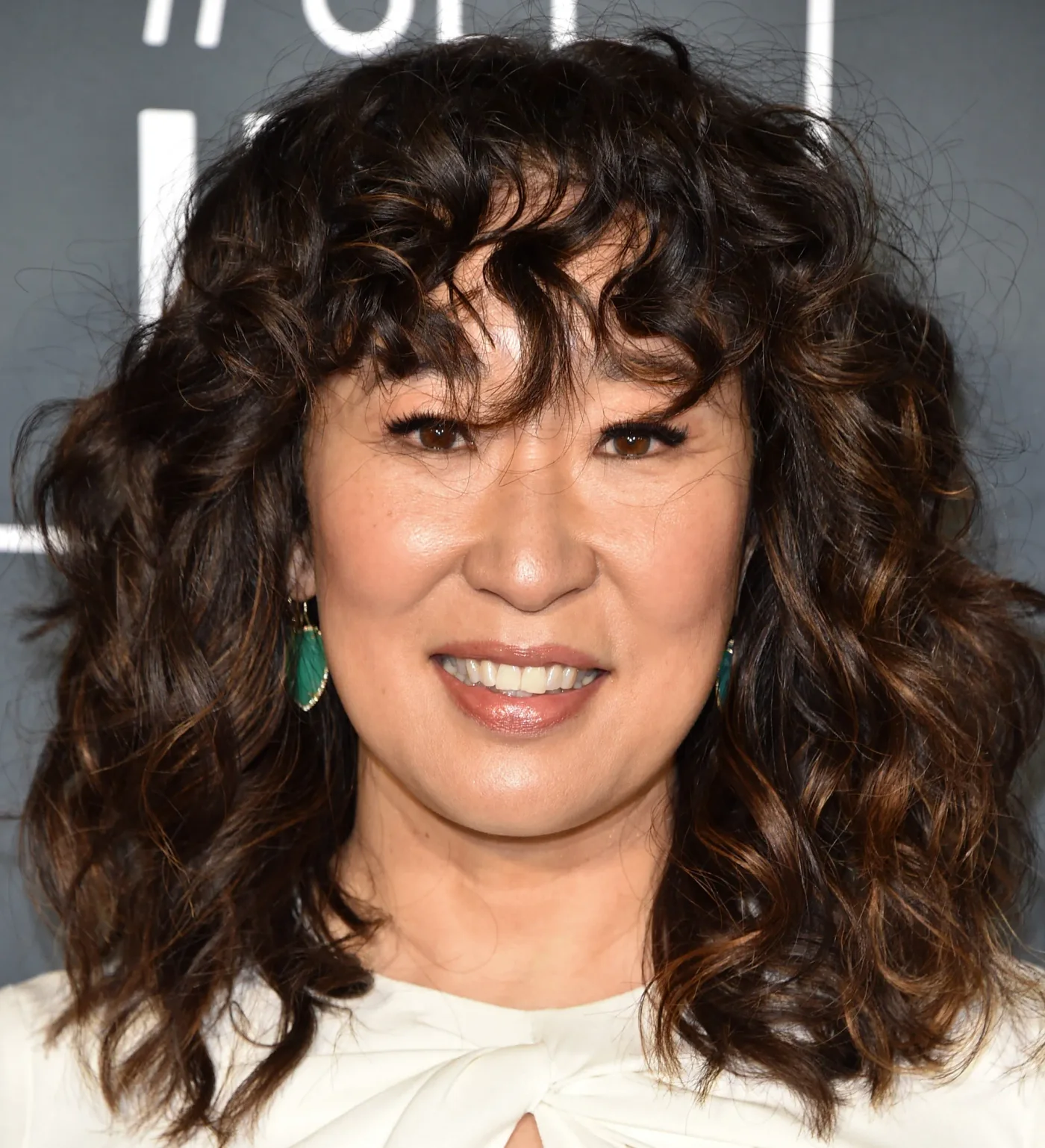 Curly medium shag haircut with curly bangs and rounded layers for thin fine hair