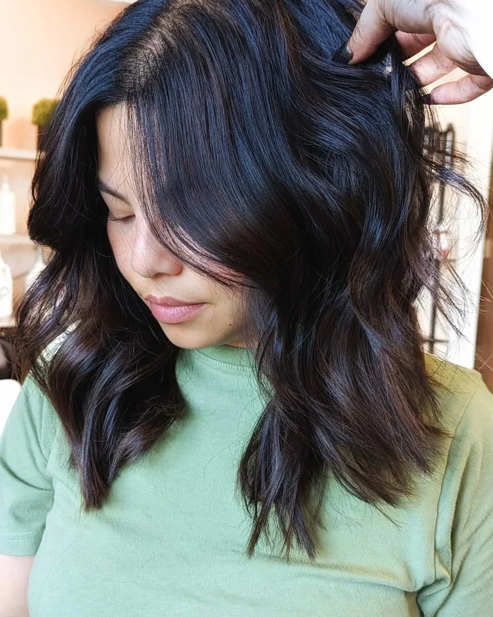 Dark tousled collarbone haircut with thick layered movement