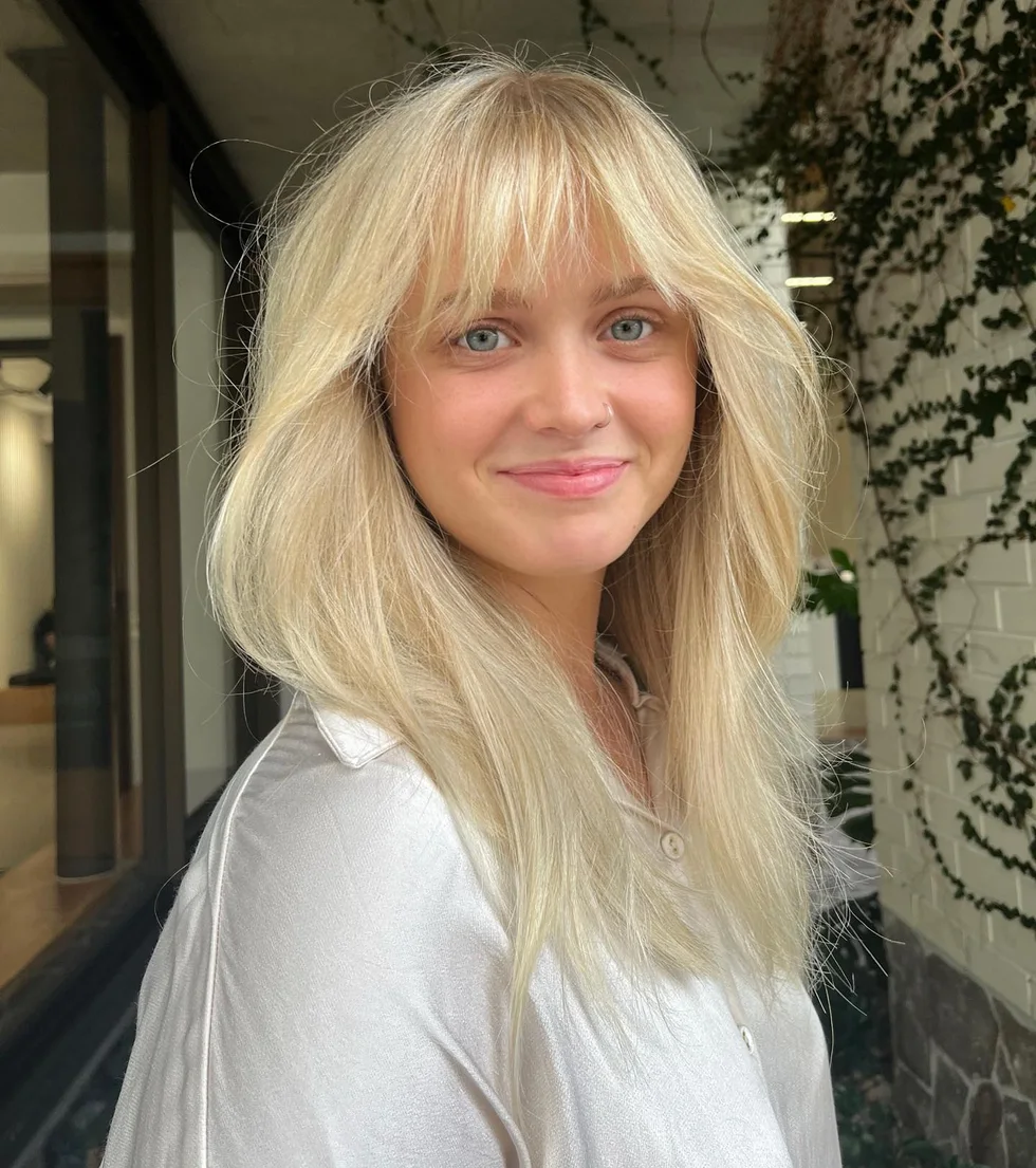 Blonde medium shag with airy bangs and thick hair texture