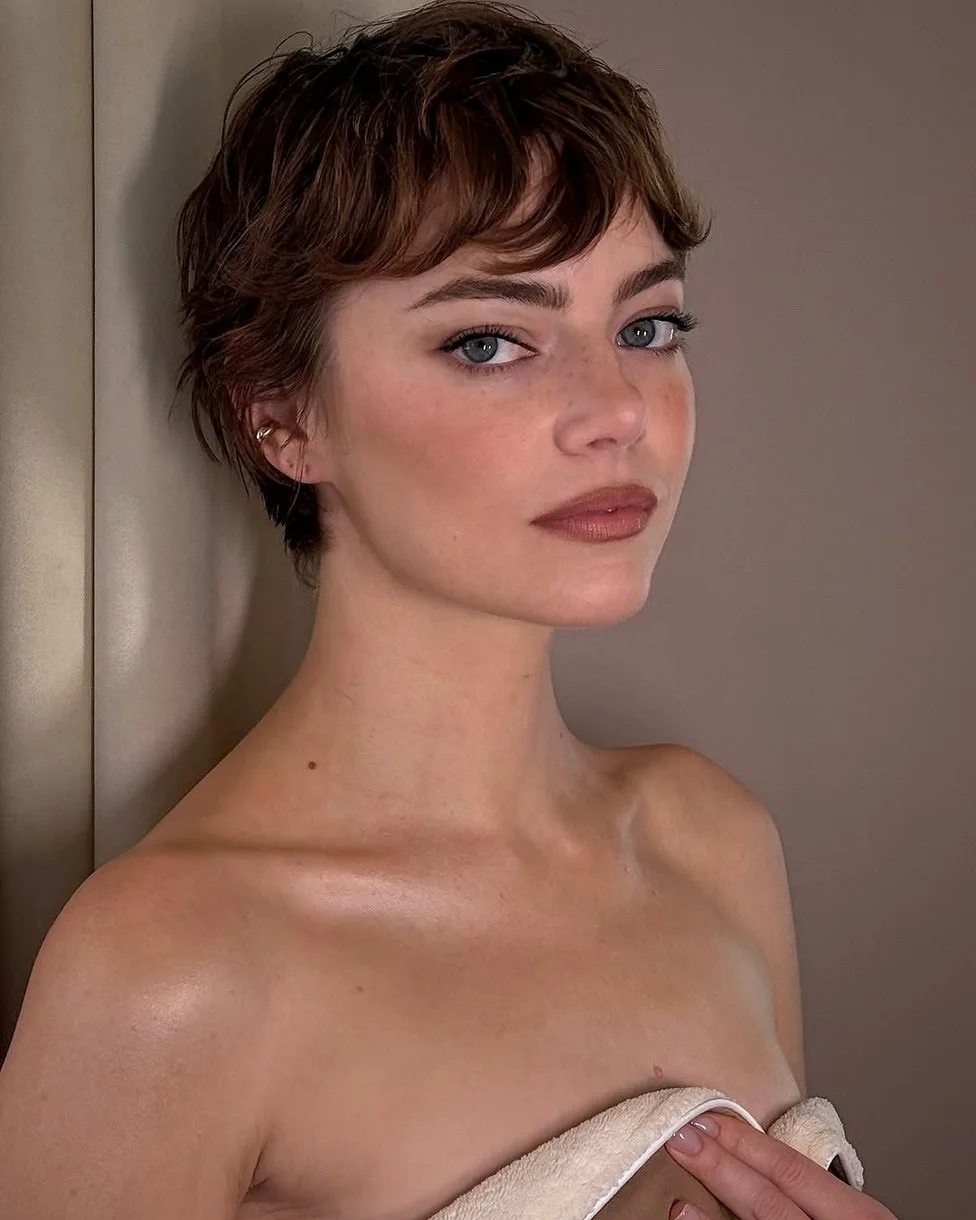 ear straight chestnut pixie with side swept fringe shown as a messy pixie cut with bangs idea, featuring straight texture