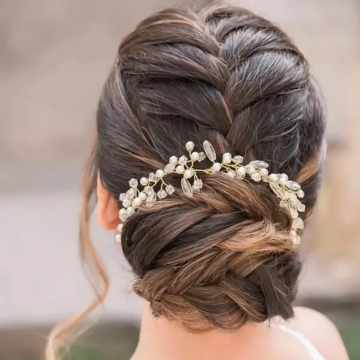 Low twisted bun with pearl pins for a mother of the bride hairstyle