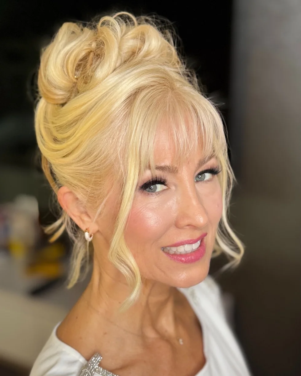 chest wavy golden updo with wispy fringe shown as a mother of the bride hairstyles idea