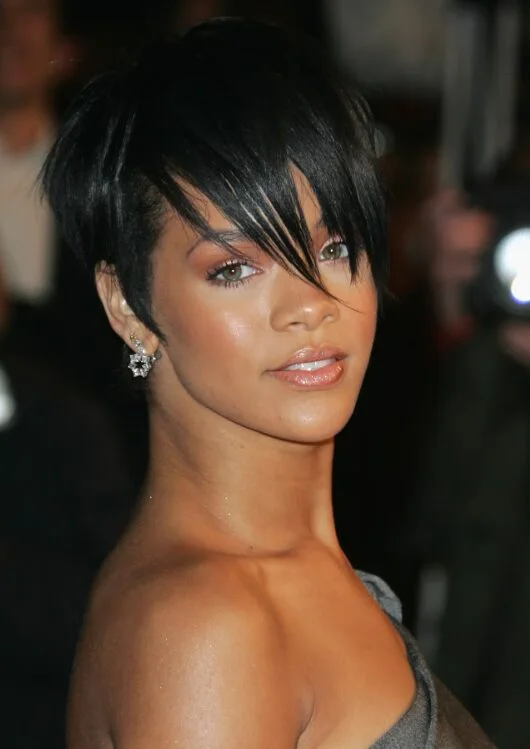 Jet black pixie cut with piecey bangs and short layered sides