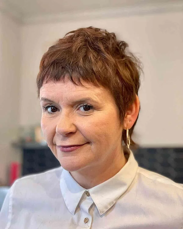Short pixie cut with tiny micro bangs and warm brunette hair