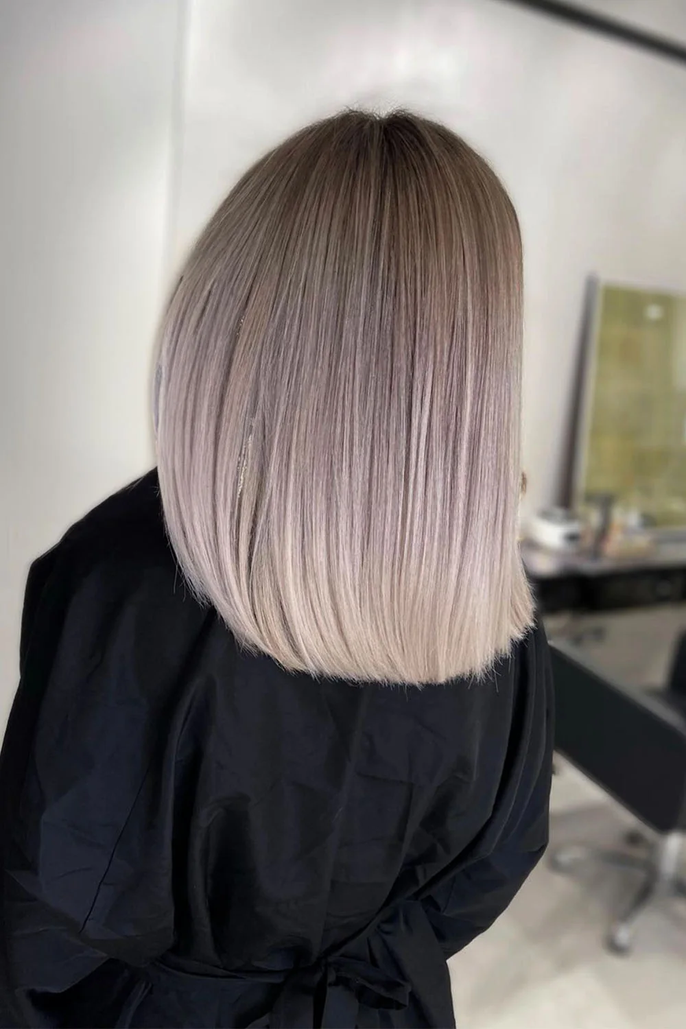Back view of a straight platinum lob with softly darker roots
