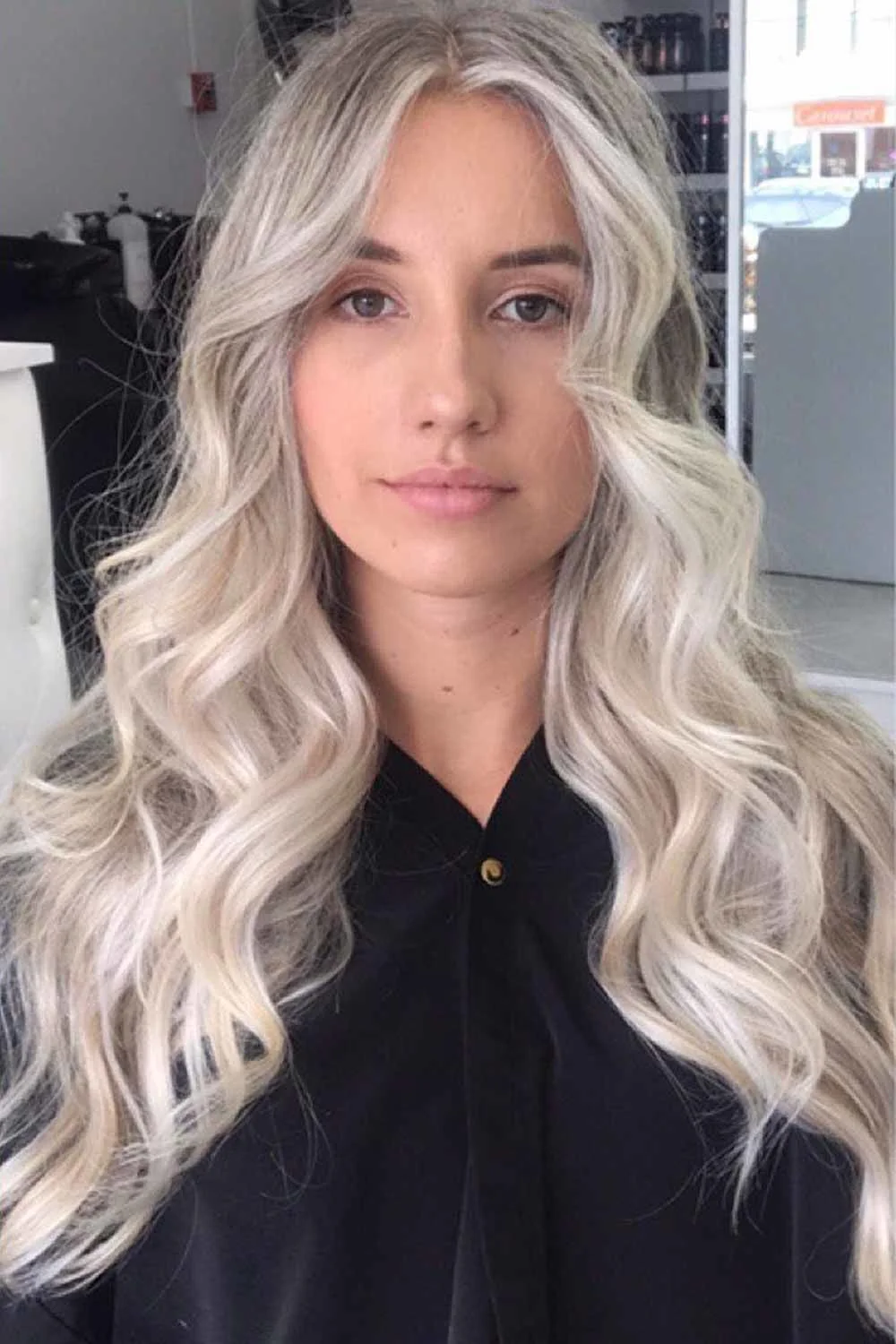 Front view of long pale blonde curls with darker root shading