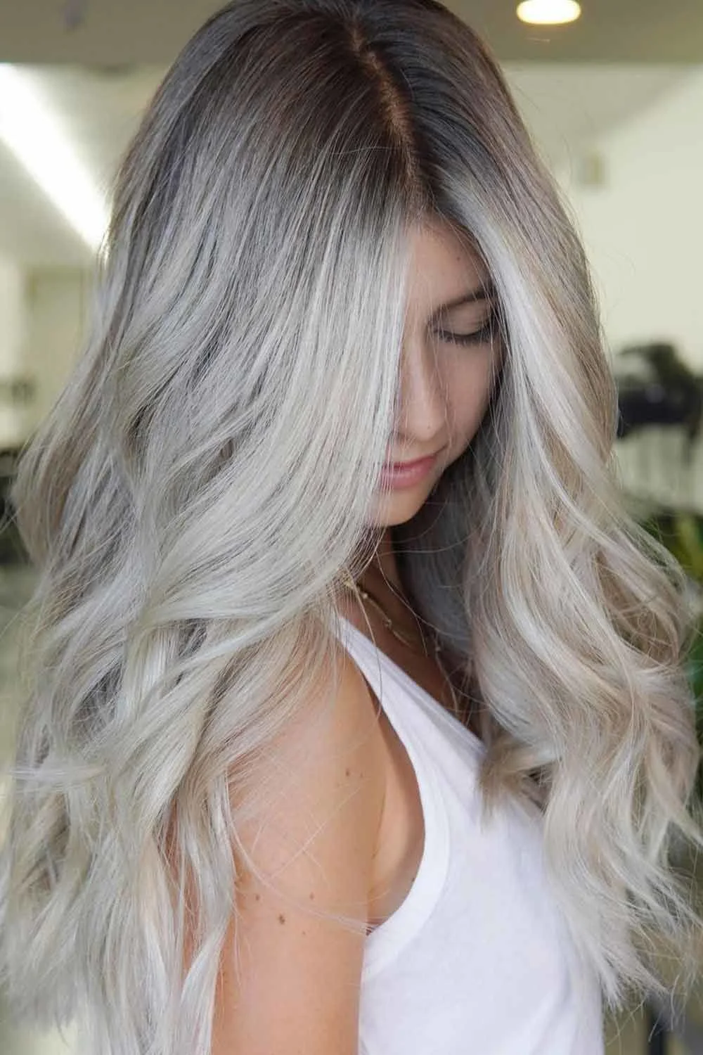Long cool blonde waves with a bright face frame and darker crown