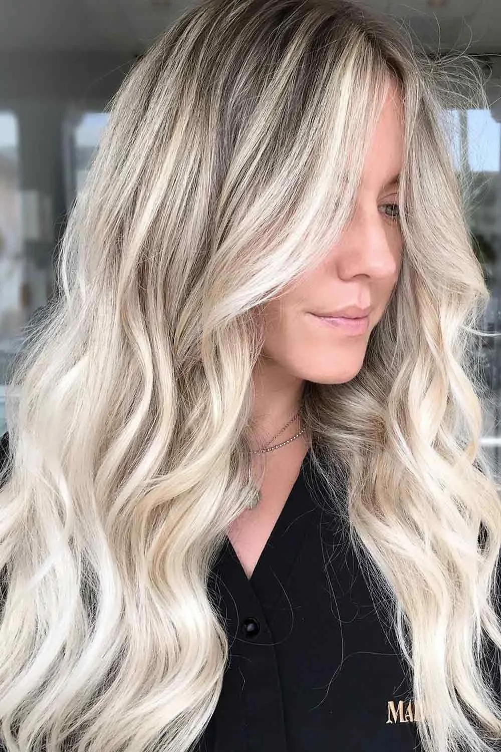 Long very light blonde waves with a softly shaded root area