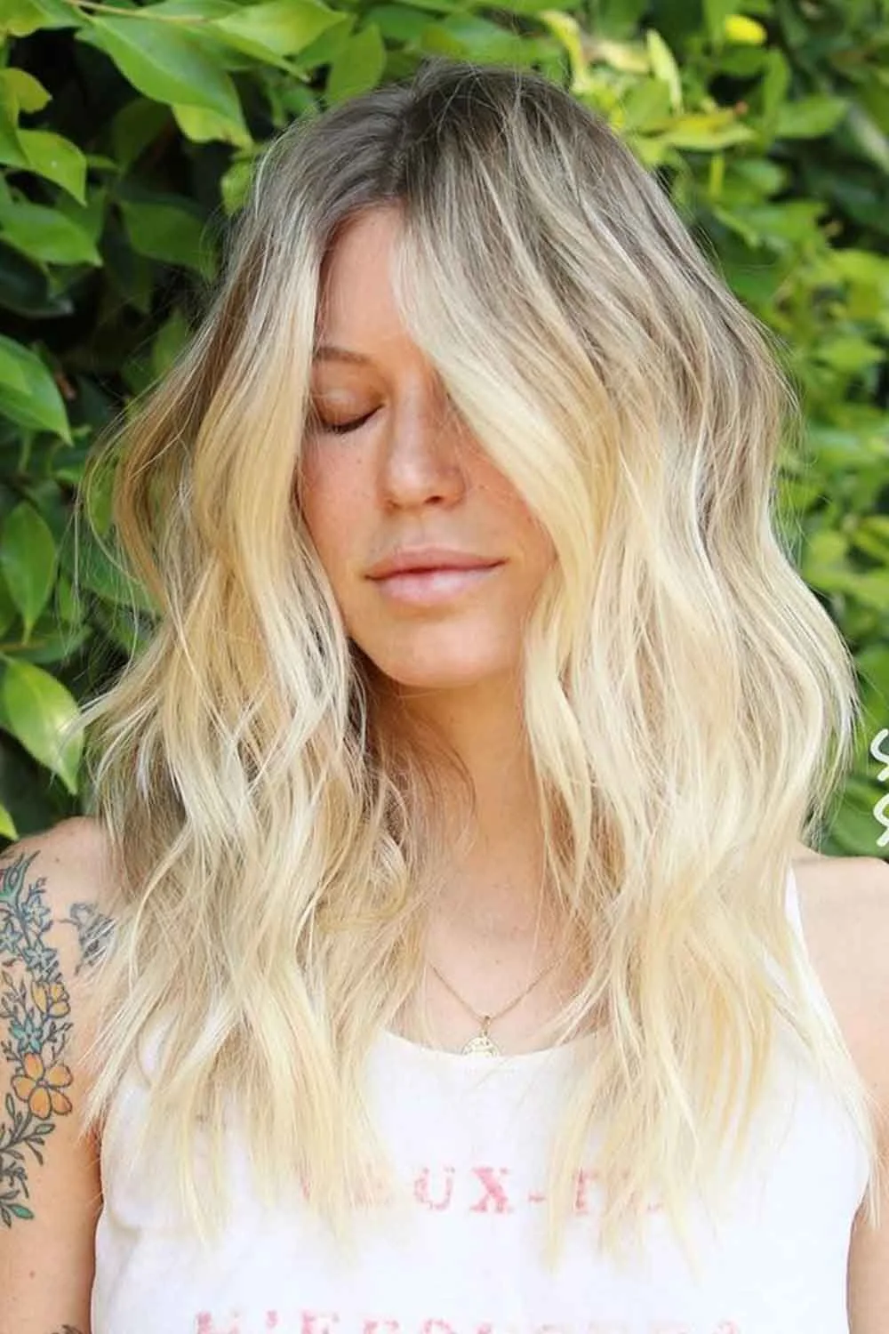 Front view of loosely waved pale blonde hair with darker roots
