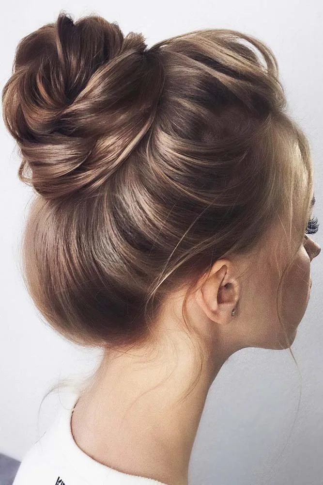 Brown hair swept upward into a smooth high knot viewed from the side