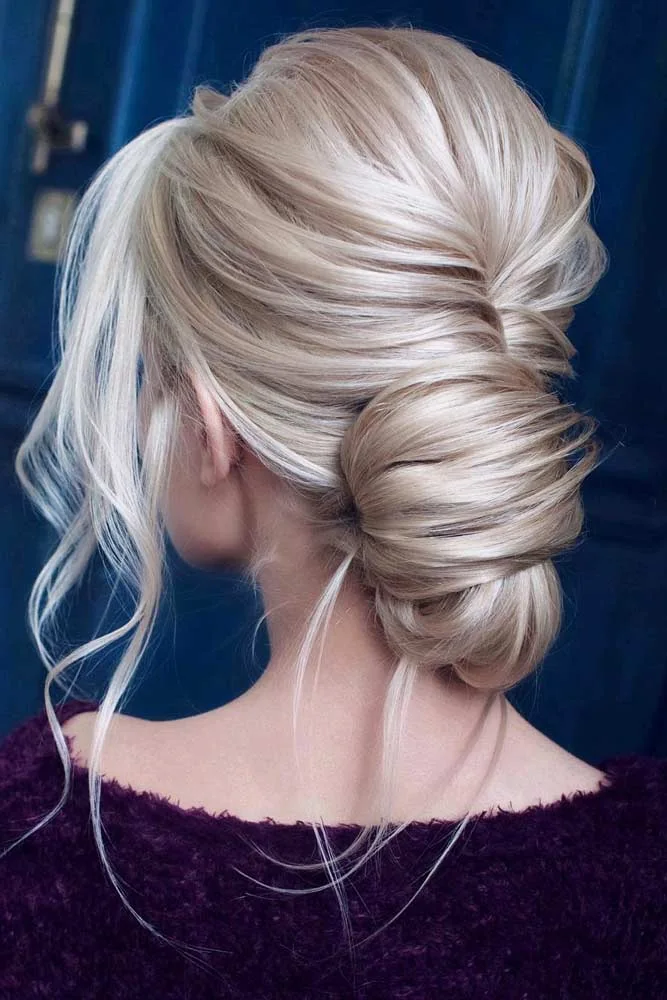 Blonde hair swept into a smooth vertical twist with a tucked lower end