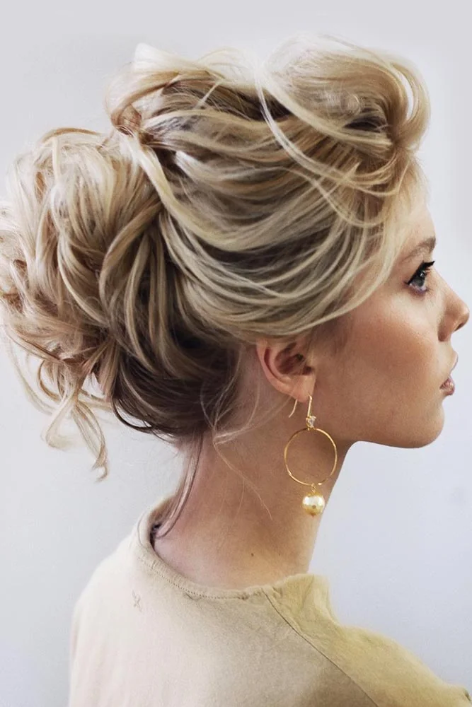 Golden blonde hair in a high loosely wrapped bun with wispy front pieces