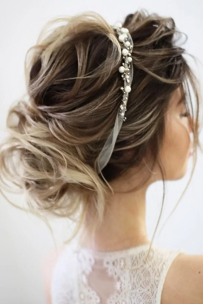 Brown-blonde hair in a low loose bun with a slim decorative clip above it