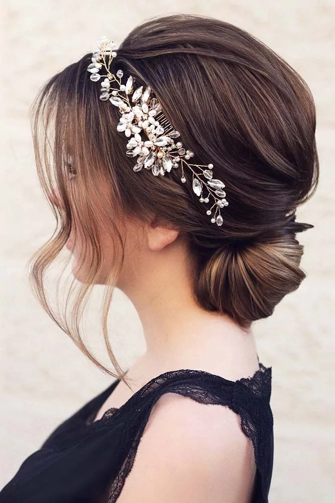 Dark hair in a compact low bun with a sparkling vine along the side