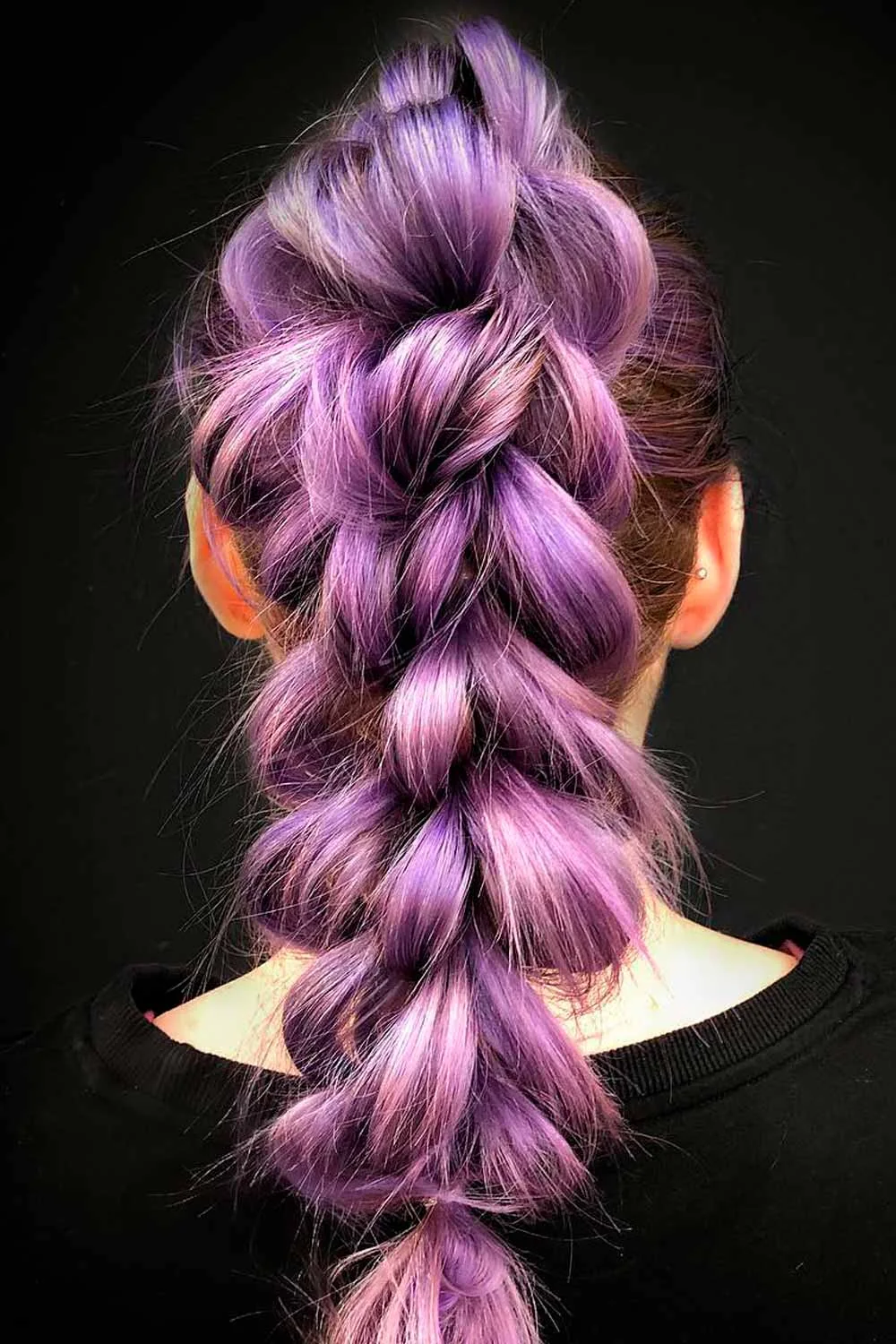 Back view of one broad lilac looped tail with darker hair at the sides