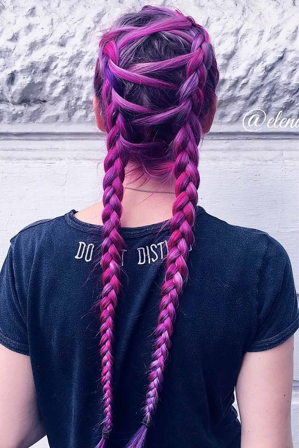Back view of purple hair with crisscrossed upper sections and two narrow braided tails