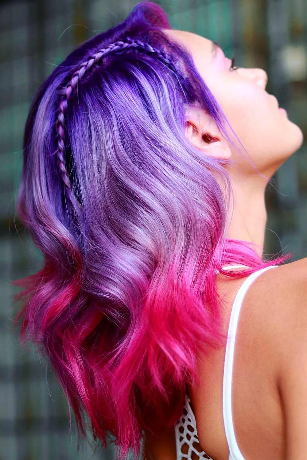 Side view of purple hair with a narrow braid above the ear and pink lower waves