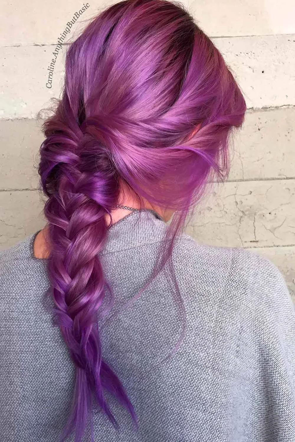 Back-side view of plum hair gathered into one loose braid beside the neck