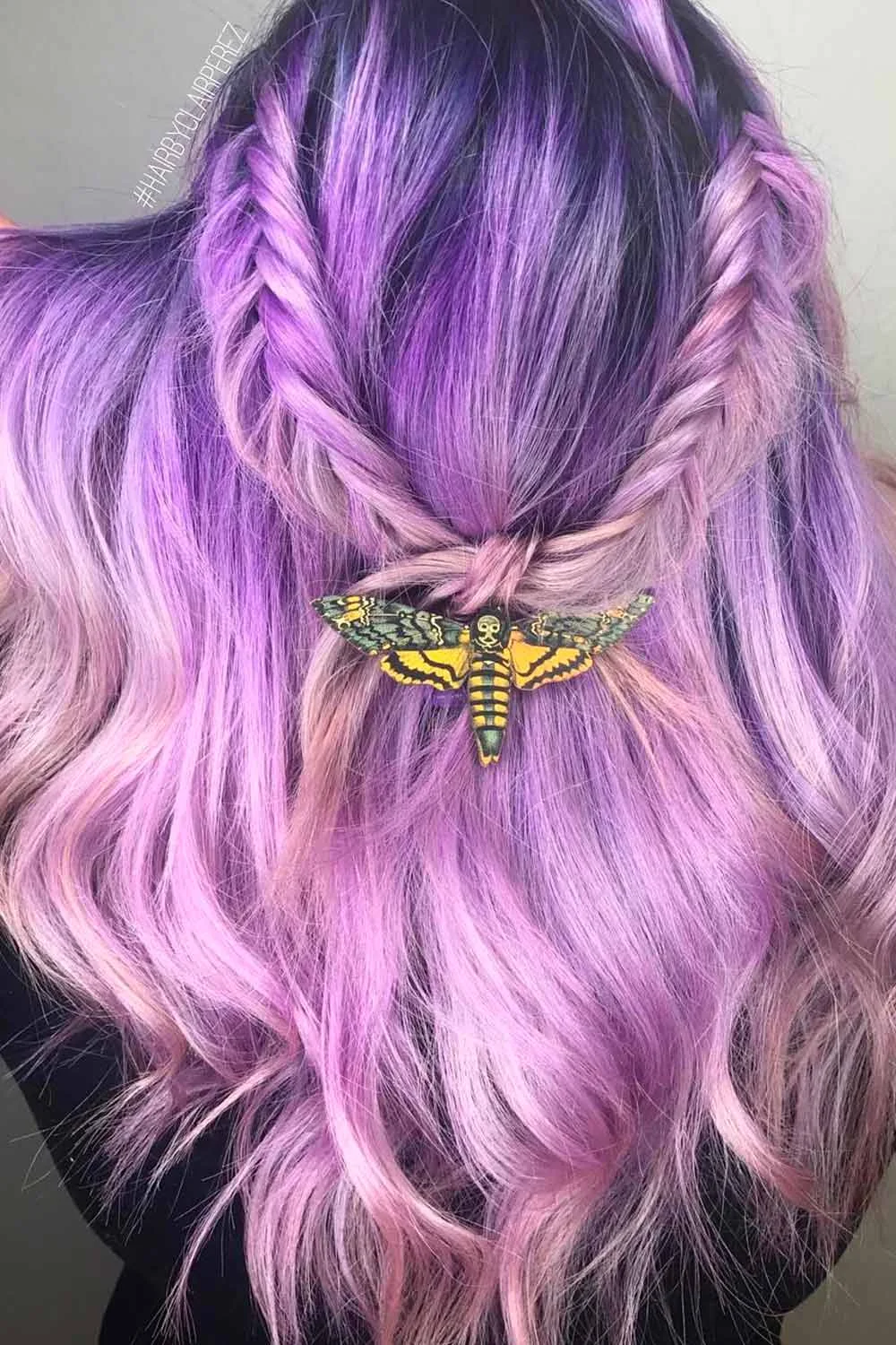 Back view of lavender and pink waves with two fine fishtail braids joined by a moth-shaped clip