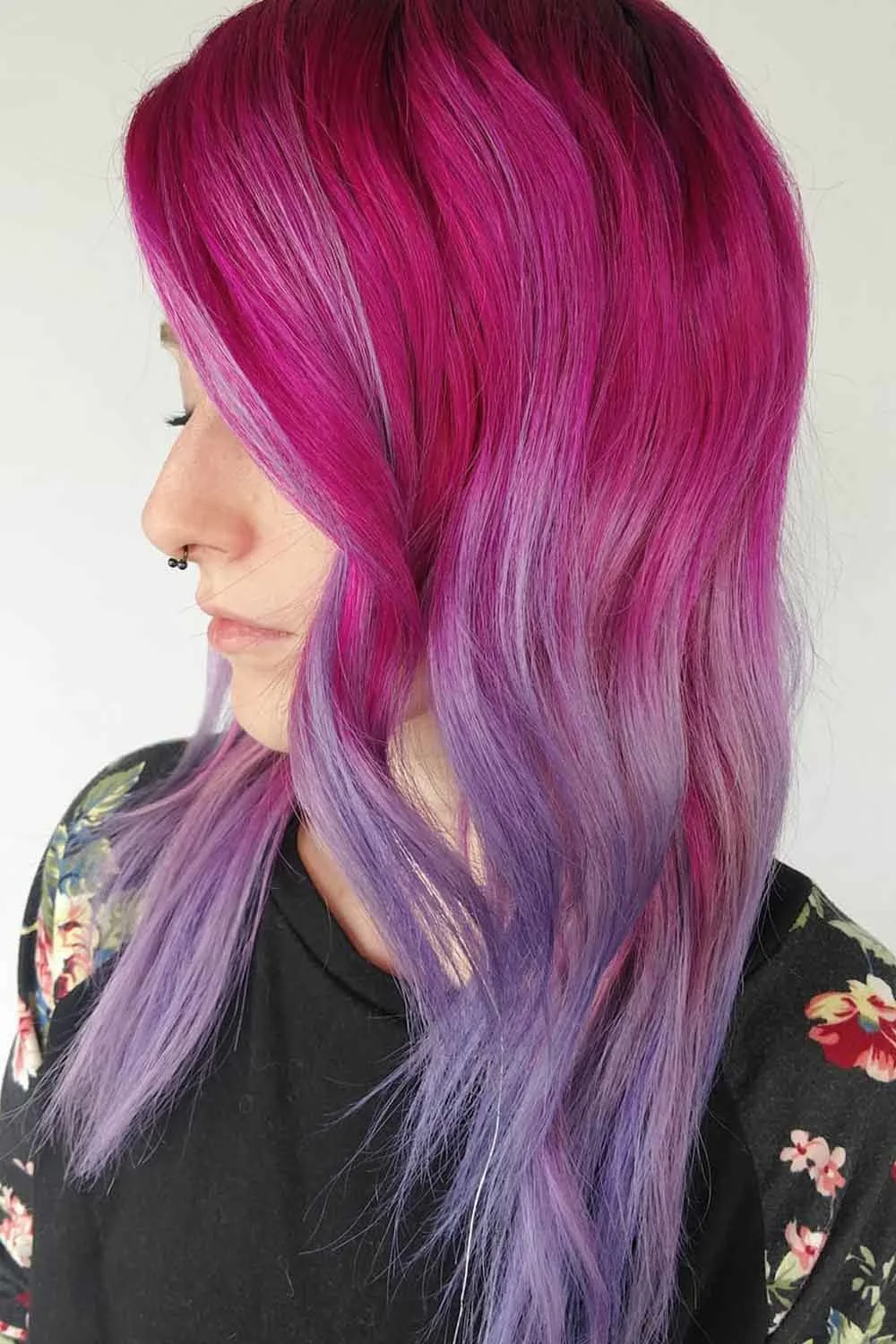 Side view of long straight hair fading from vivid magenta at the crown to soft lavender at the ends