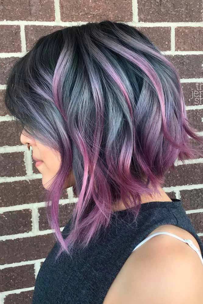 Side view of an angled bob with charcoal roots, silver-lilac ribbons, and longer front pieces