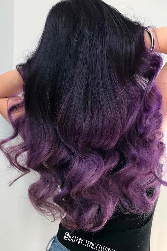 Back view of long dark wavy hair with muted plum color through the middle and ends