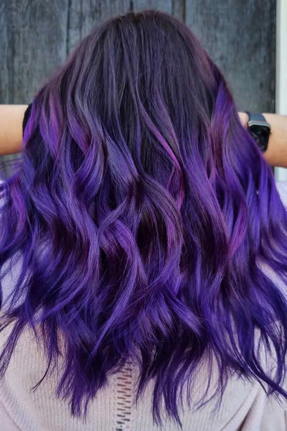 Back view of dark shoulder-length waves with saturated violet ribbons concentrated through the lower half