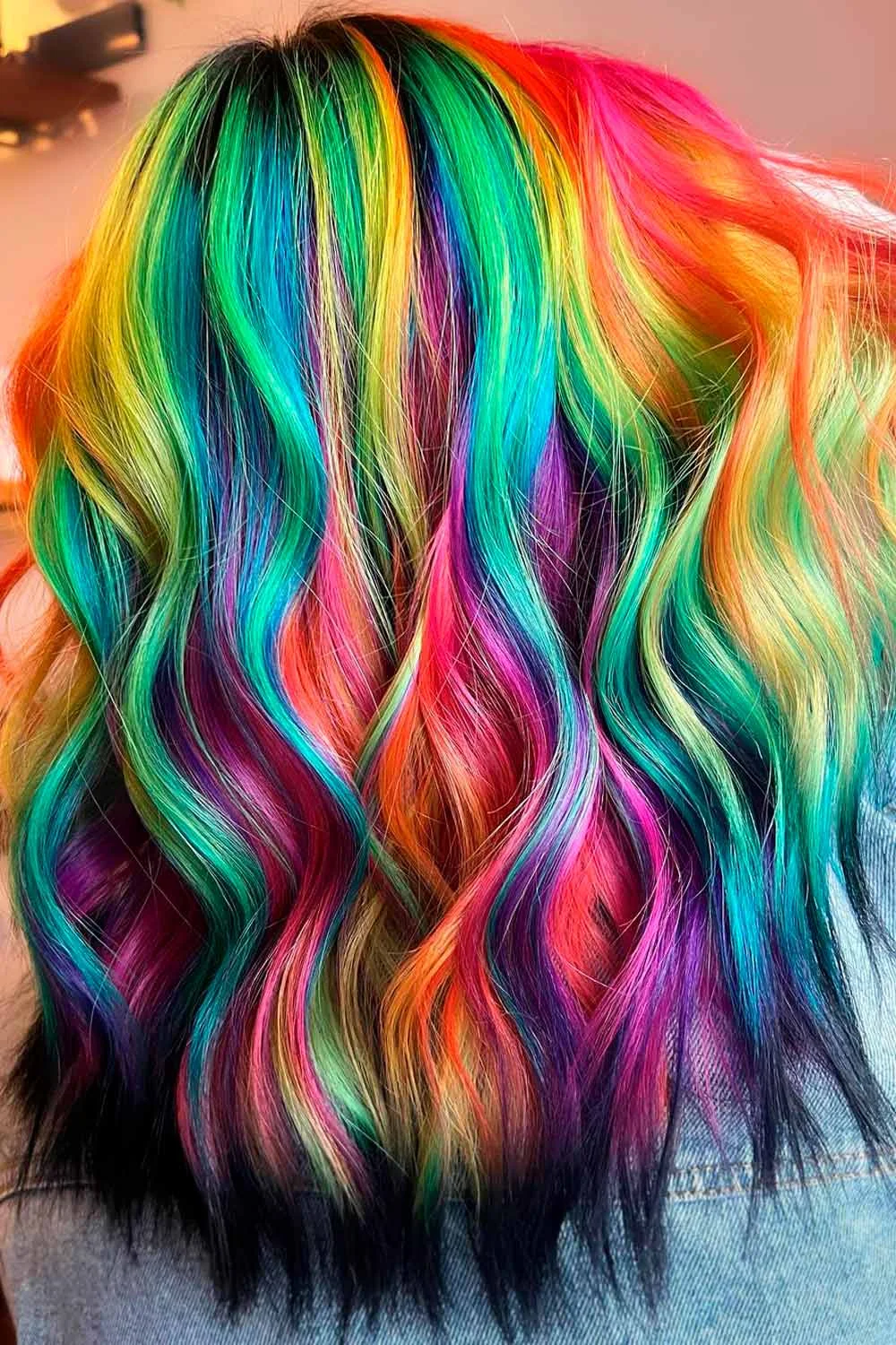 Back view of short neon rainbow waves with green, yellow, orange and pink above black ends