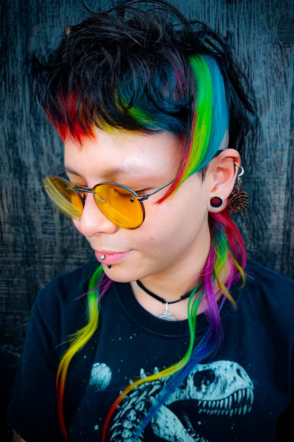 Side portrait of a short dark mullet with green-blue side panel and colorful longer nape