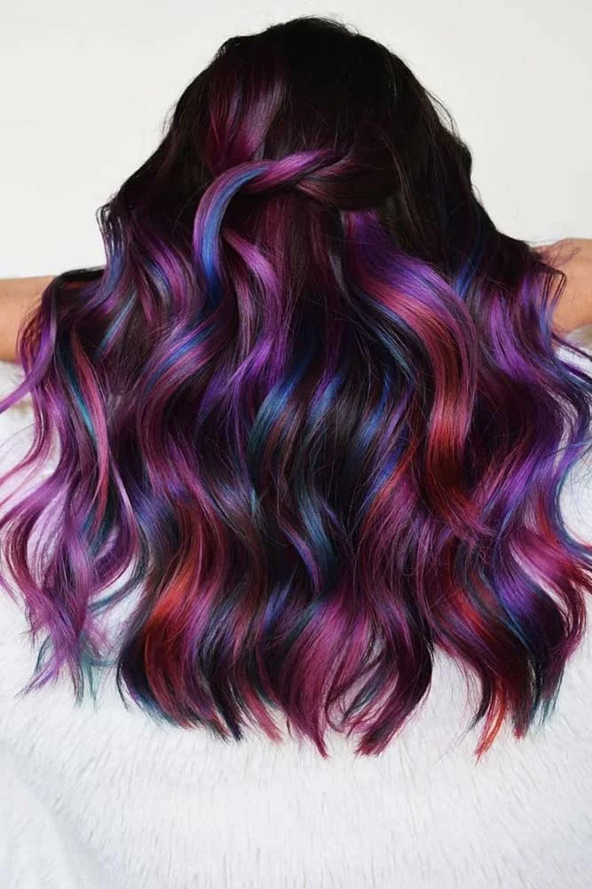 Back view of dark shoulder-length waves with violet, blue and red jewel-tone ribbons