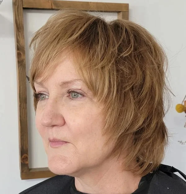 shoulder wavy silver shag with curtain fringe shown as a shaggy hairstyles for women over 50 idea, featuring center part