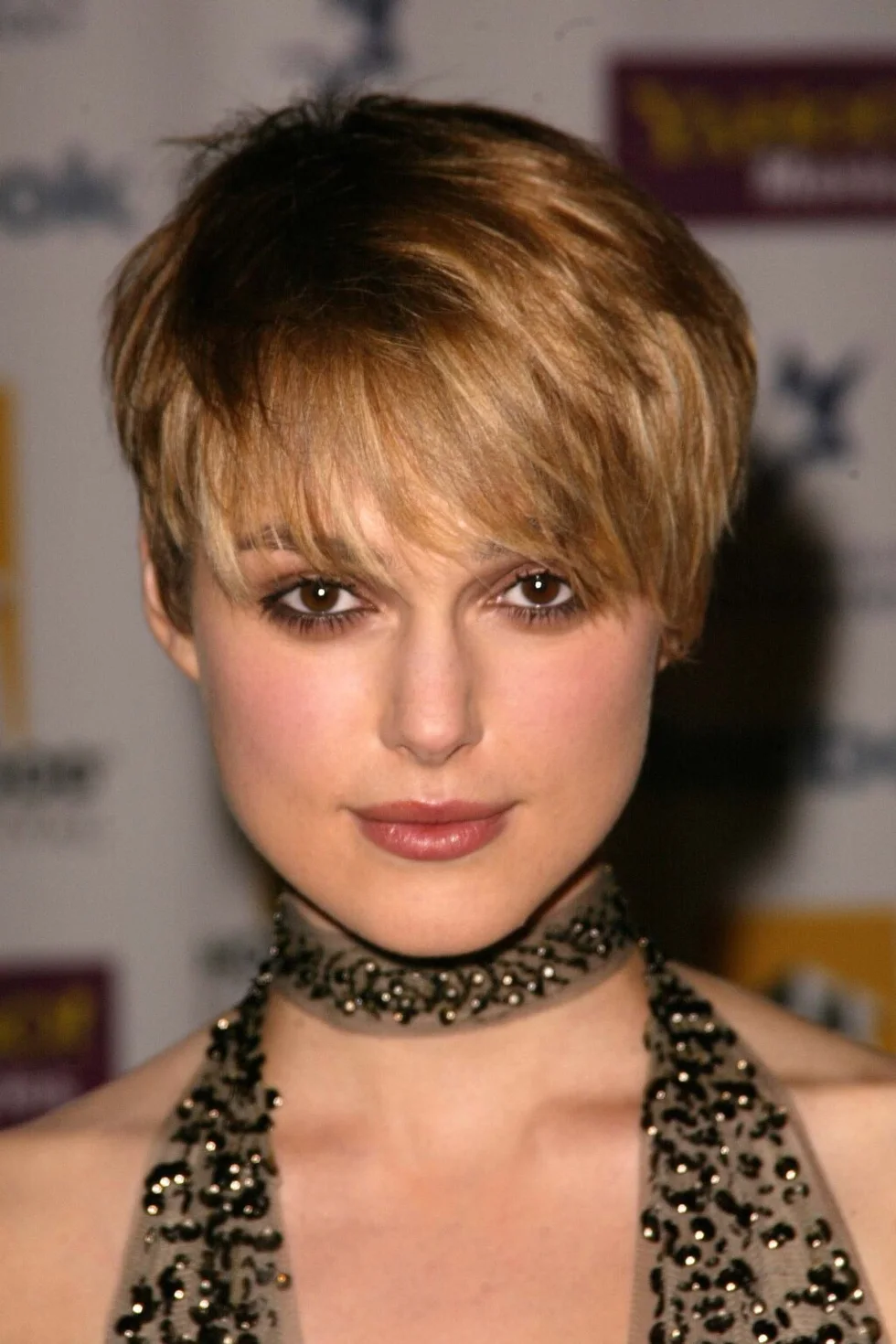 ear straight golden pixie with wispy fringe shown as a shaggy pix mullet idea, featuring medium layering
