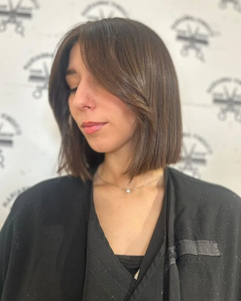 Soft black short bob with a deep side part and angled front