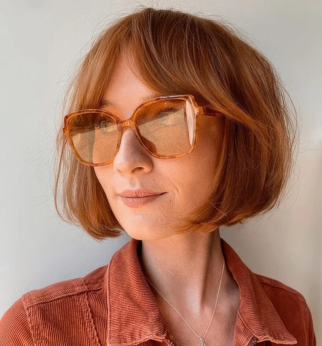 Short ginger bob with bottleneck bangs.