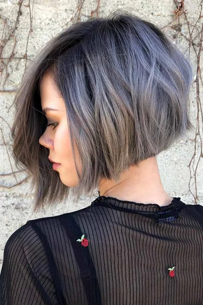 Side view of a gray angled bob with darker roots and longer front ends