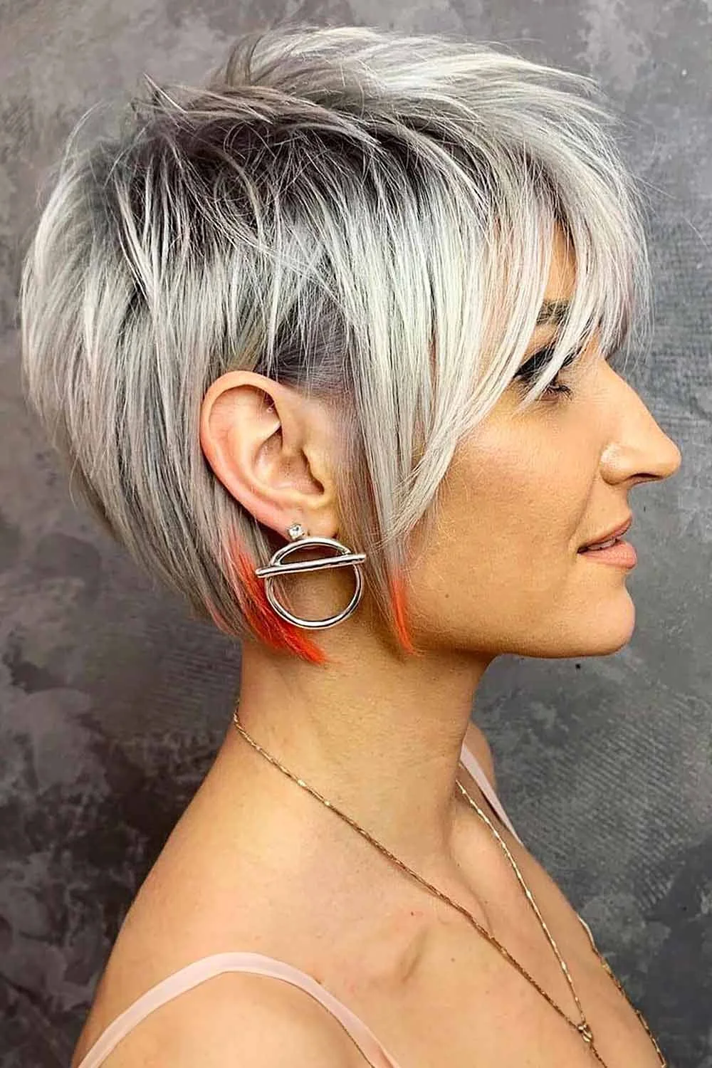 Side view of a layered silver pixie with short sides and a long sweeping front