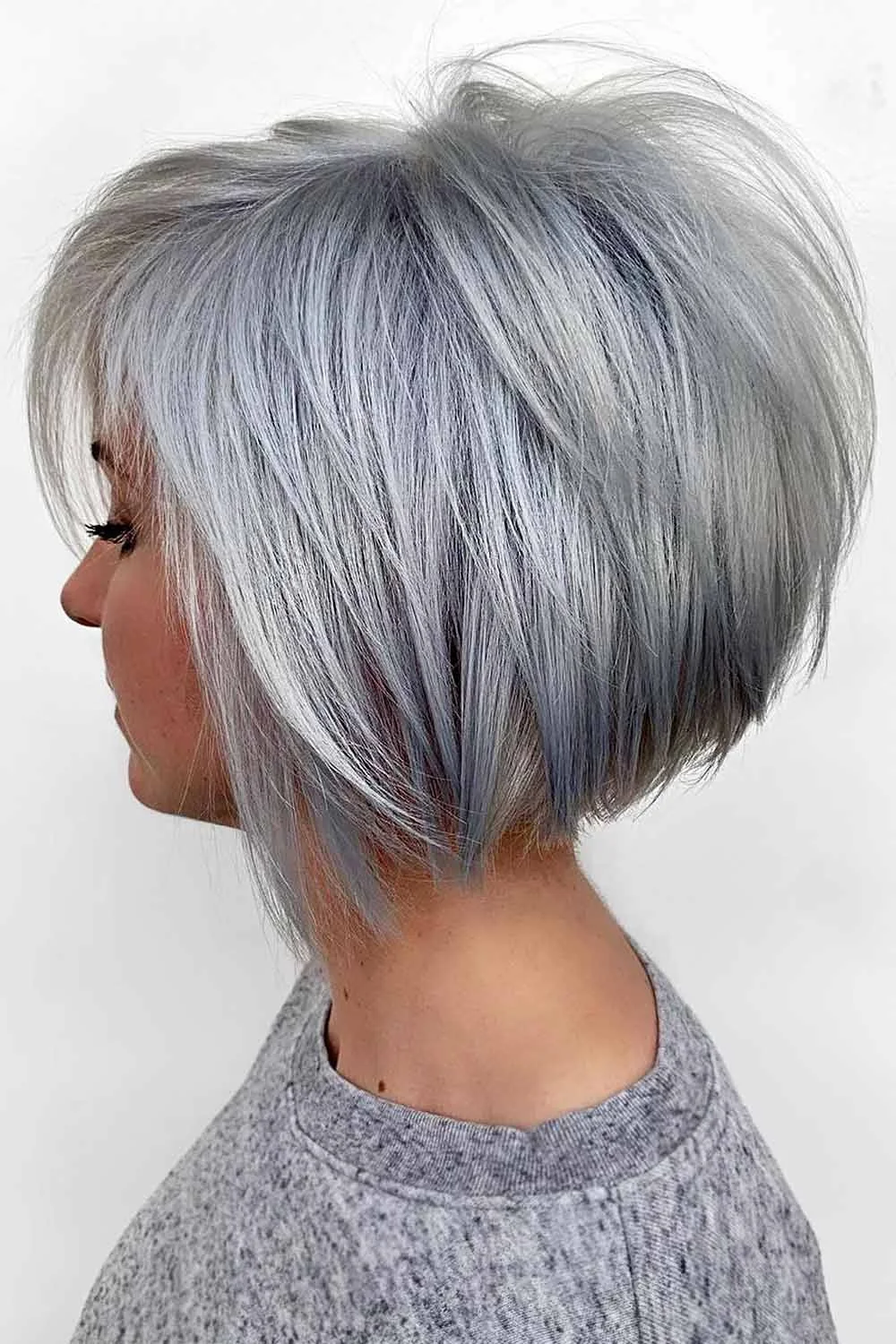 Side view of a layered silver bob with darker lower strands and a softly tapered nape