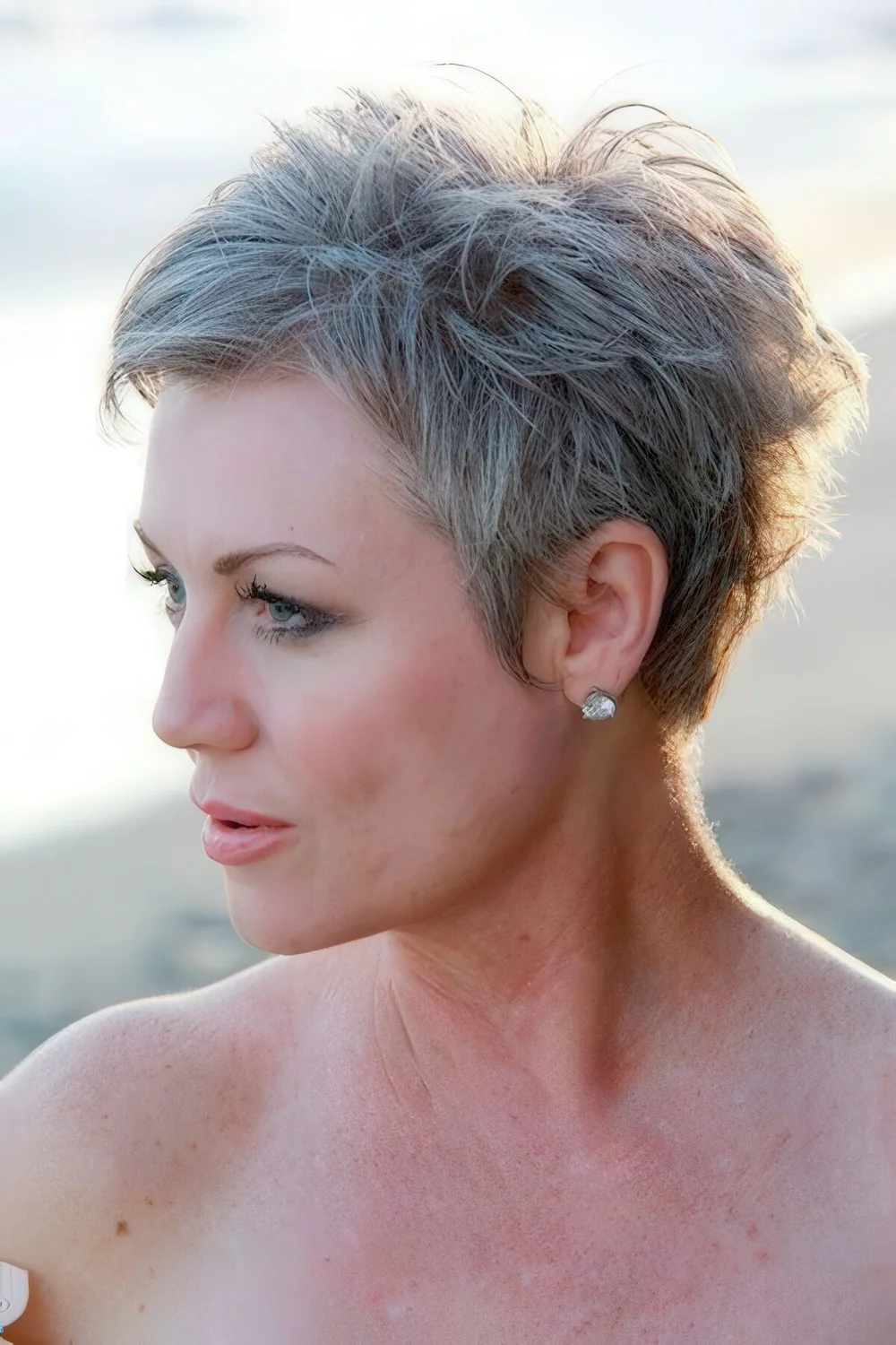 Short pixie textural haircut with grey hair.