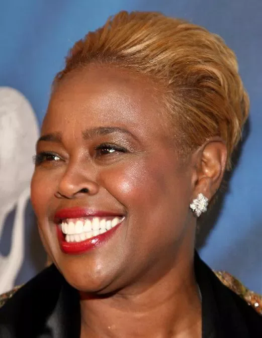 Older Black woman with a golden short cropped hairstyle and soft brushed-back texture
