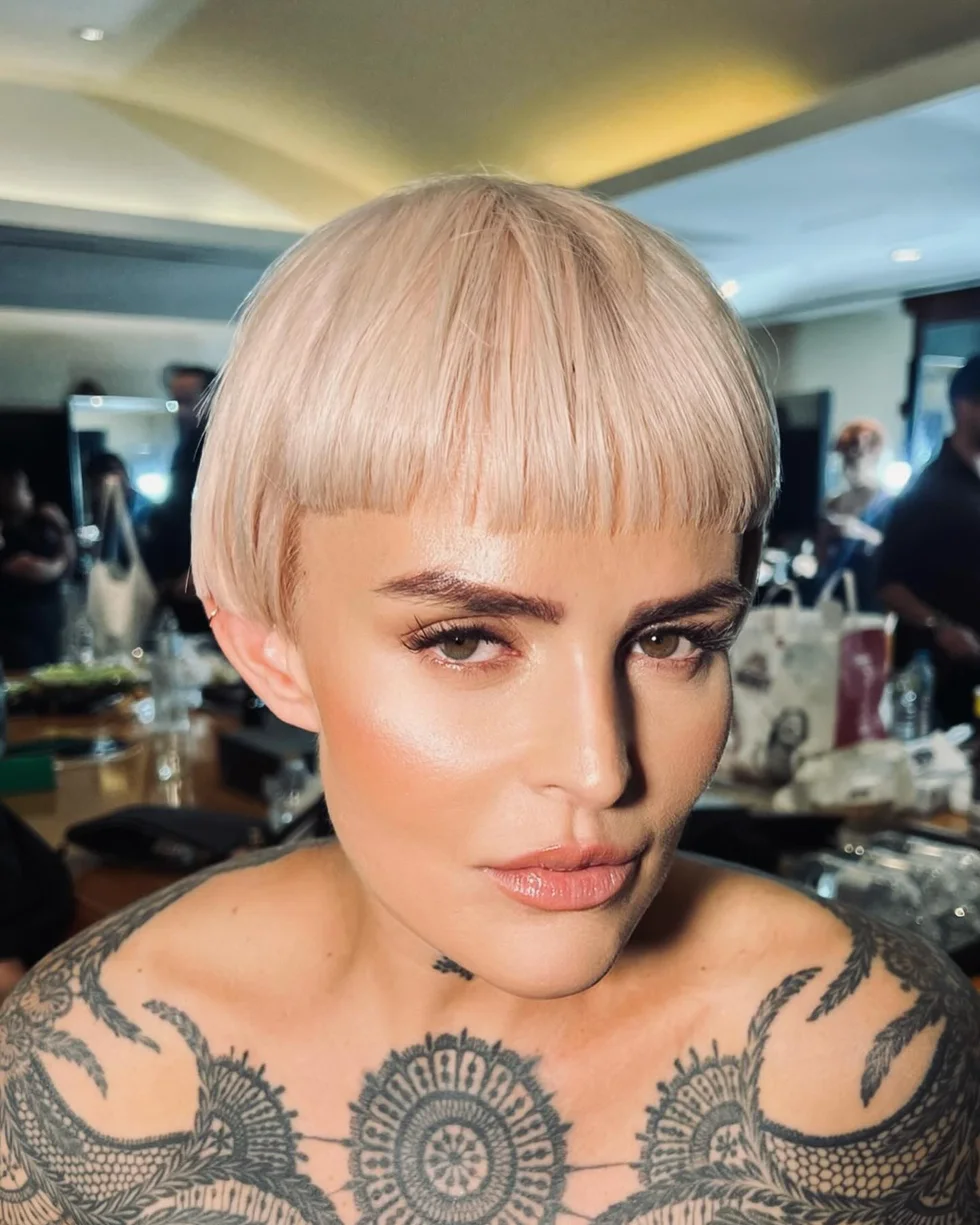 platinum bowl pixie with a short blunt fringe, rounded top, and closely cropped sides on a round face with thin hair