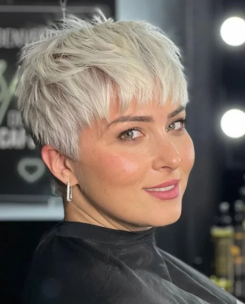 white feathered pixie with wispy bangs, short sides, and light top separation on a round face with thin hair