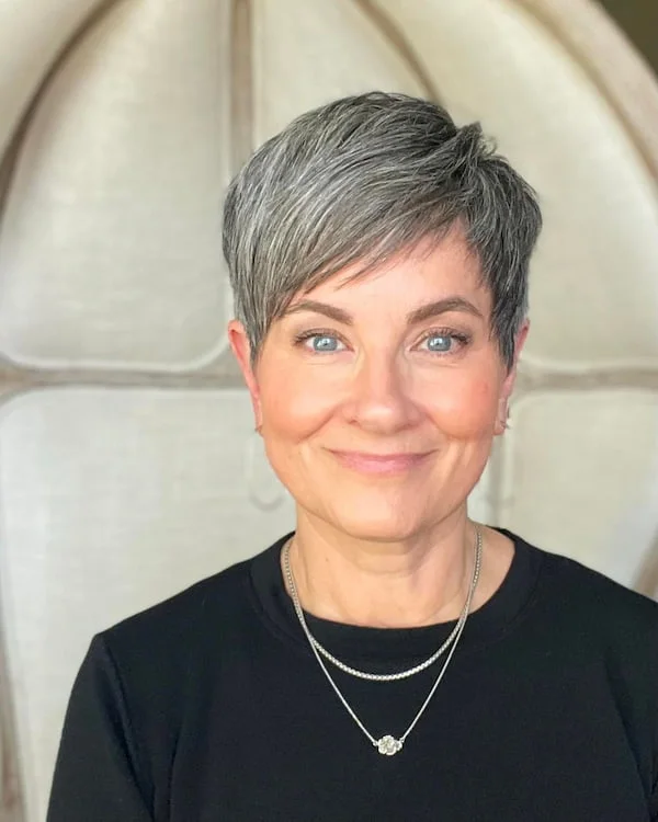 silver crop with an angled side fringe, tapered temple, and smooth crown on a round face with thin hair