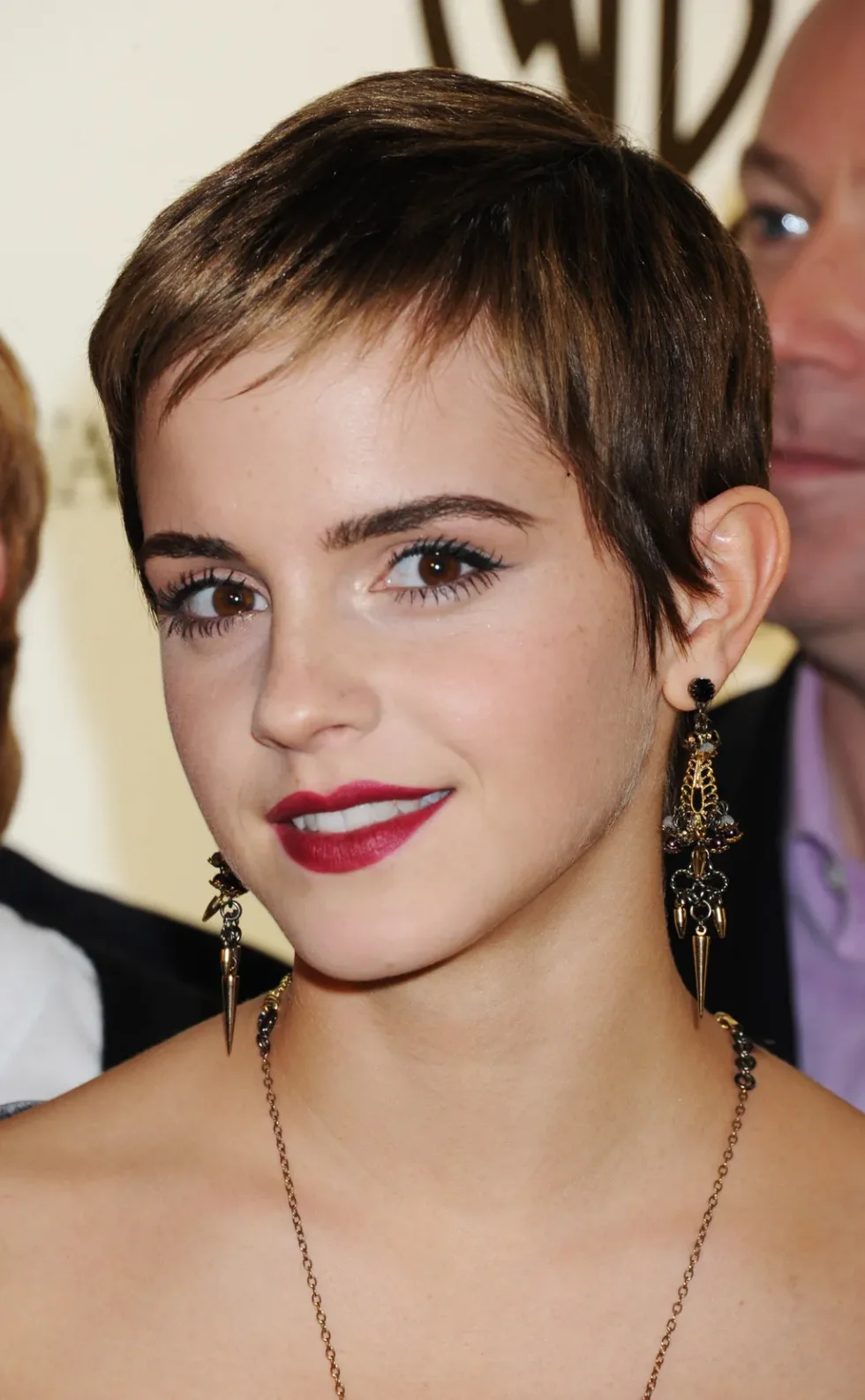 neat brunette pixie with a short side sweep, tucked temple, and clean ear line on a round face with thin hair