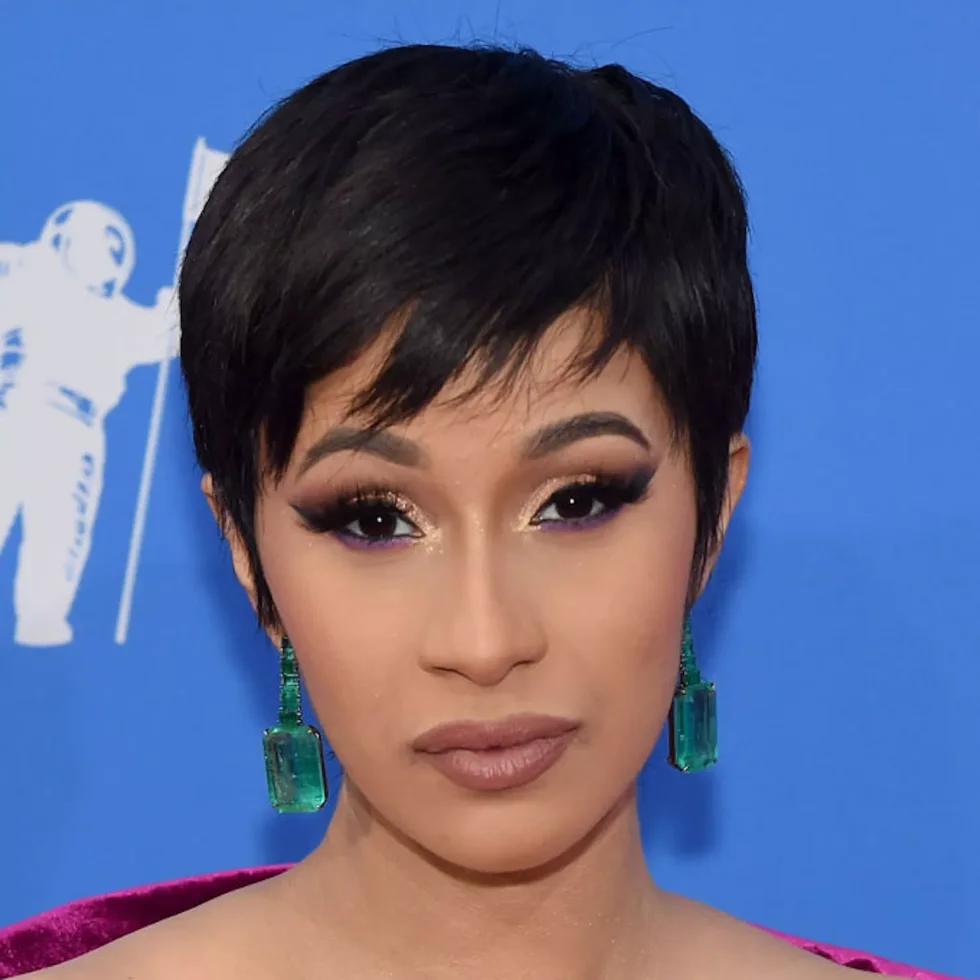 black pixie with a long side-swept fringe, lifted crown, and closely shaped sides on a round face with thin hair