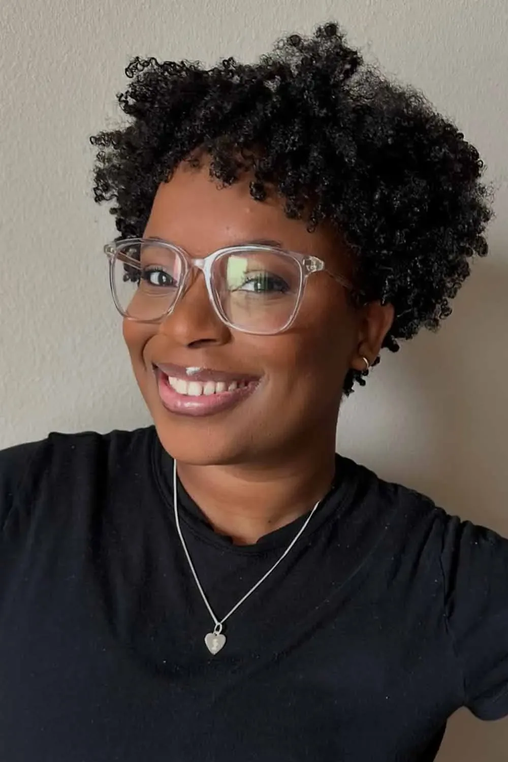 ear coily black curly style shown as a short natural hairstyles for black women over 50 idea, featuring black color, shown in coily hairstyle