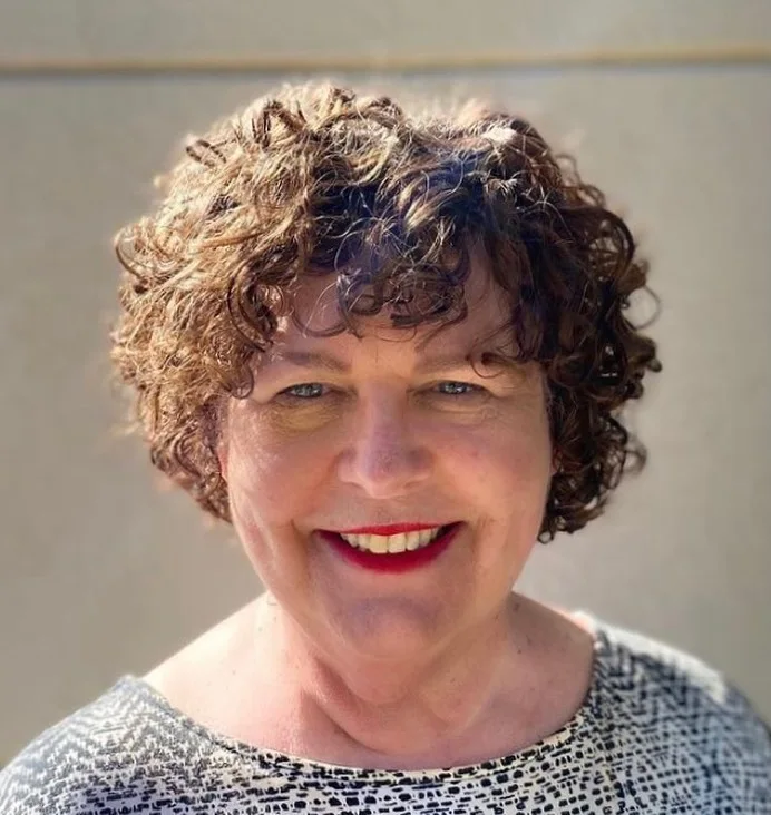 Curly brunette short pixie haircut for an older woman with natural volume