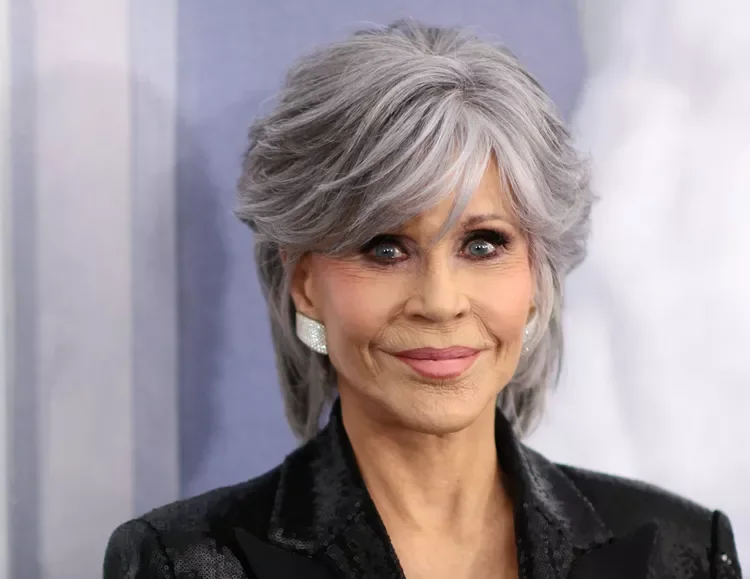 Feathered silver short pixie haircut for an older woman with side fringe