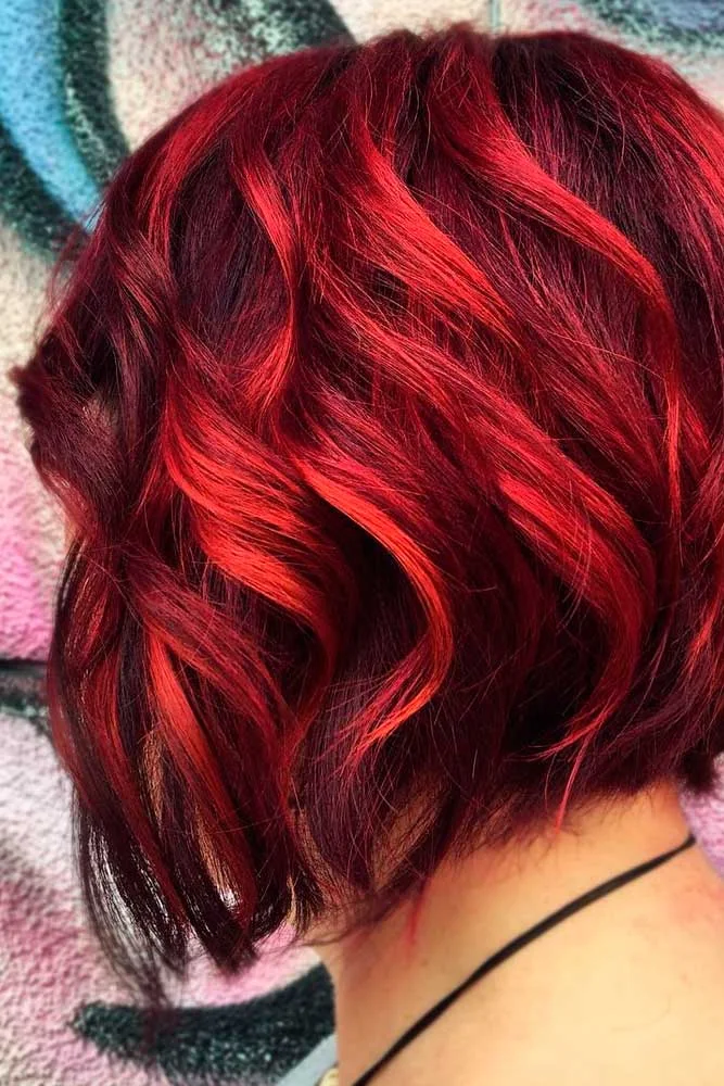 Back view of a short layered bob with black-red depth and bright ruby waves